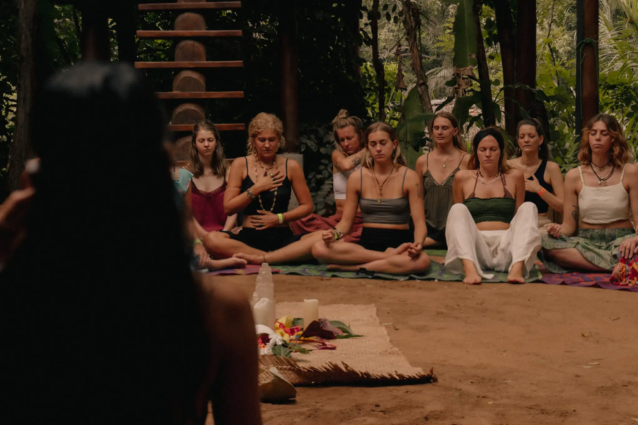 A facilitator holding space for a group in meditation in the garden at Senses